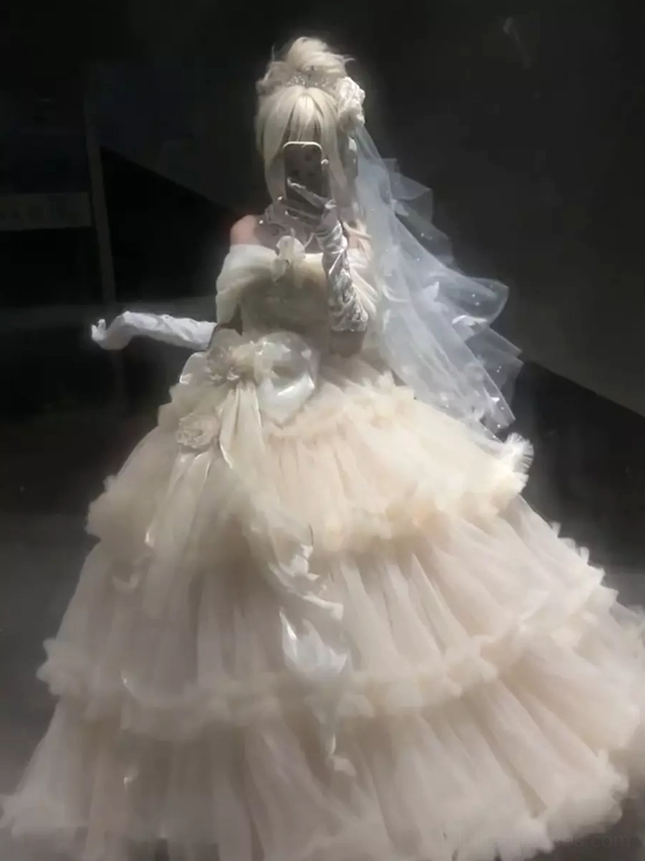 Model wearing champagne sweet lolita wedding gown with bridal veil long white gloves back three-quarter view