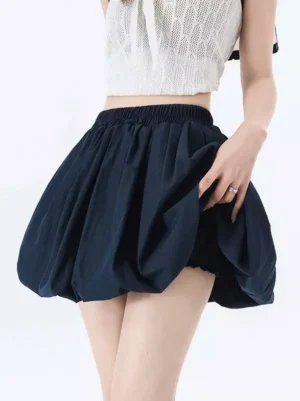 Navy blue elastic waist bubble mini skirt with high-rise voluminous pleated hem, dark sophisticated color perfect for gothic lolita styling, shown with cropped white knit top