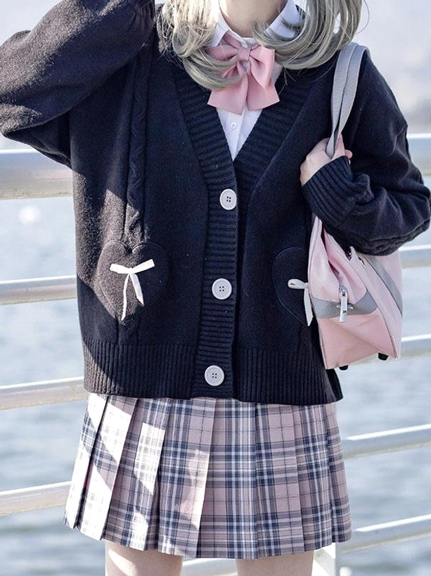 Navy blue lolita cardigan sweater with bow pockets and pink bow tie accent displayed on model with pink backpack