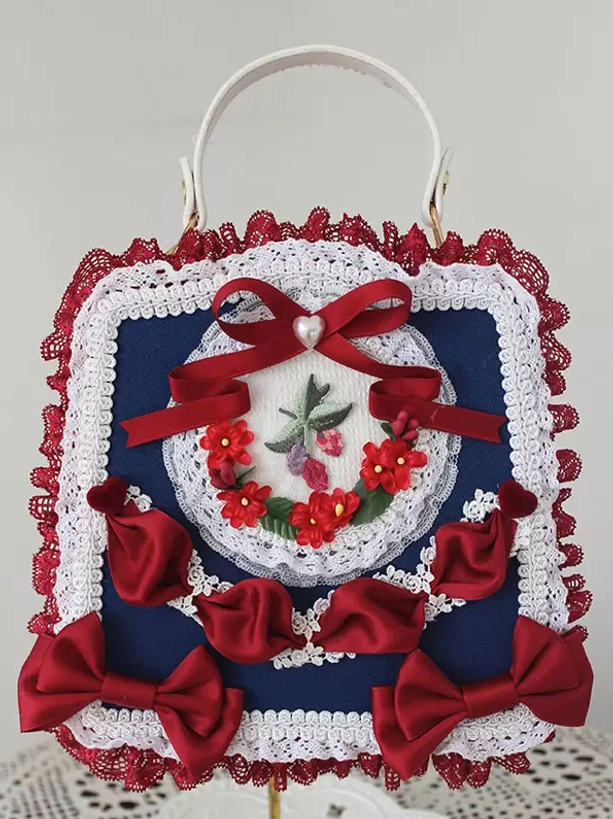 Navy blue lolita PU leather handbag with red satin bows lace trims red floral embroidery on display stand