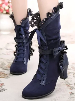 Navy blue Rococo Lolita winter boots featuring perforated trim ruffle decorations and prism block heel with lace-up closure system displayed on ornate interior backdrop