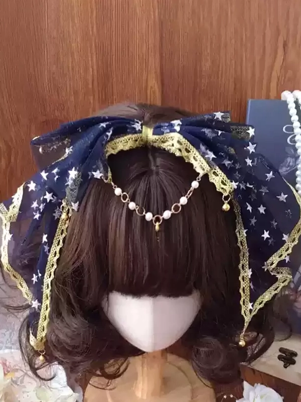 Navy blue star-print tulle lolita bow headband with gold lace trim and pearl forehead pendant chain on brown wig mannequin