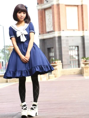 Navy sailor sweet lolita one-piece dress with white bow collar, front view on model in outdoor street setting