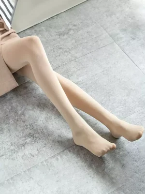 Nude skin-toned semi-sheer lolita pantyhose on sitting model, side view showing smooth surface and closed-toe construction