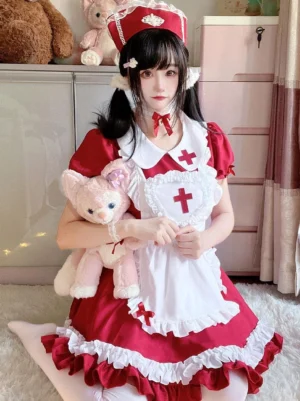 Front kneeling three-quarter view of red-white nurse sweet lolita dress with ruffled trims, puffy short sleeves, cross ornament, and twin-tailed model showcase