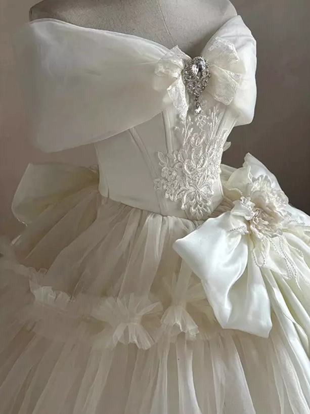 Rear view of off-shoulder Lolita wedding dress with rhinestone bow embroidered bodice and waist floral decoration