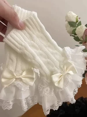 Off-white sweet lolita knitted wrist cuffs with cable knit texture lace ruffle trims satin bow and layered tulle decorated with artificial roses close-up detail
