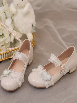 Off-white sweet lolita mary jane pumps with ruffled ankle strap and heart buckle, chunky block heel, flat lay overhead shot with stuffed toy and flower decoration