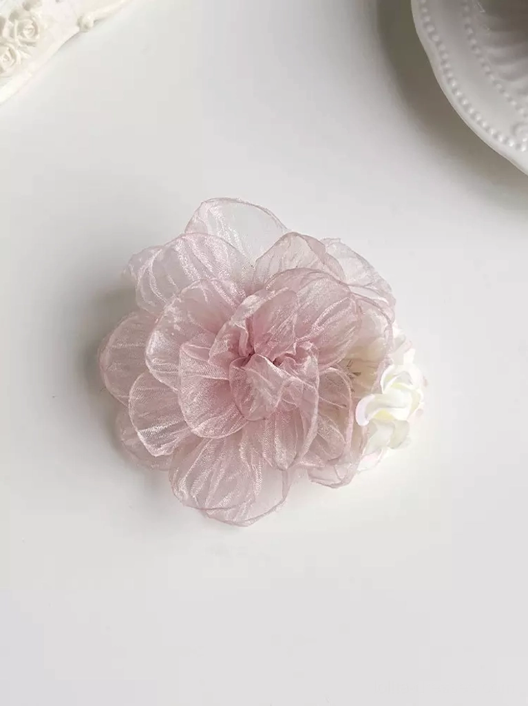 Organza flower hair accessory for sweet lolita with layered pink sheer petals shown in top-down flat lay on white background