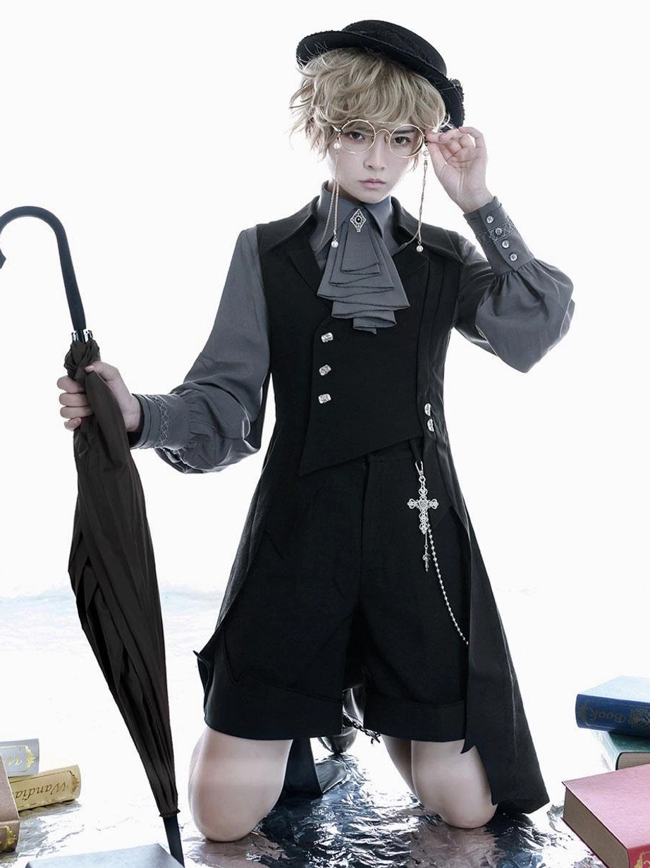 Ouji lolita overcoat front kneeling view androgynous model asymmetrical tailcoat cross chain ornament grey shirt wet floor book props gothic aesthetic