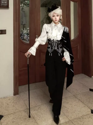 Gothic Ouji Lolita cape cloak outfit full front view white-haired model ruffled blouse embroidered cummerbund single black cape with silver trim formal black pants vintage aesthetic