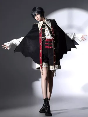 Gothic prince lolita ensemble three quarter angle showing structured bat wing cape with red and gold decorative trim details