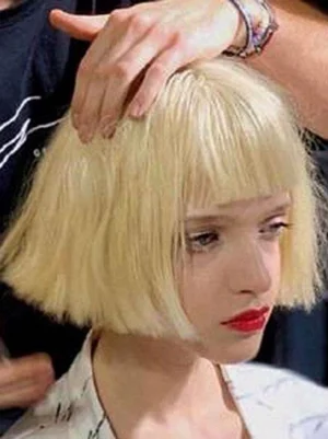 Pale blonde short bob lolita wig with blunt bangs shown on model during fitting adjustment, side view demonstrating sleek bob texture and rococo elegance