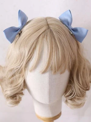 Sweet baby blue matte satin bow hair clips worn on blonde curly wig mannequin head demonstrating lolita headdress styling for sweet lolita fashion coordinate