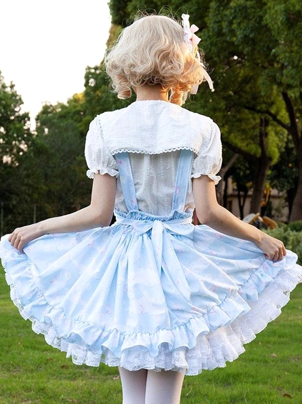 Pastoral lolita skirt back view showcasing big decorative back bow, puff short sleeves, floral printed light blue flared skirt with ruffled lace trim, outdoor setting
