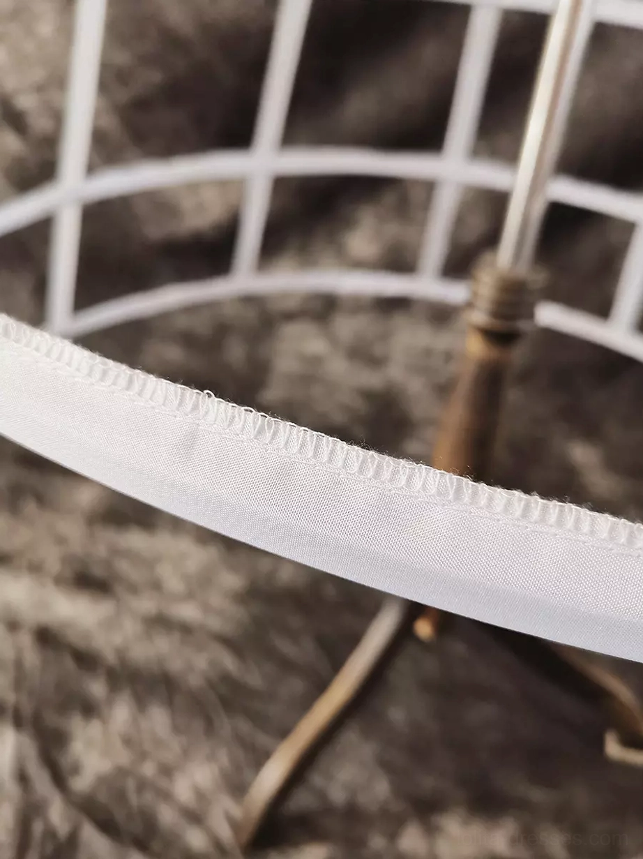 Petticoat hoop binding detail low-angle close-up showing white hoop reinforcement and metal support structure