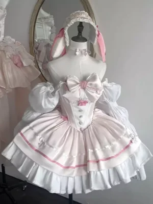 Pink ballet lolita dress with layered ruffles front view on dress form featuring bunny ear headband and prominent front chest bow