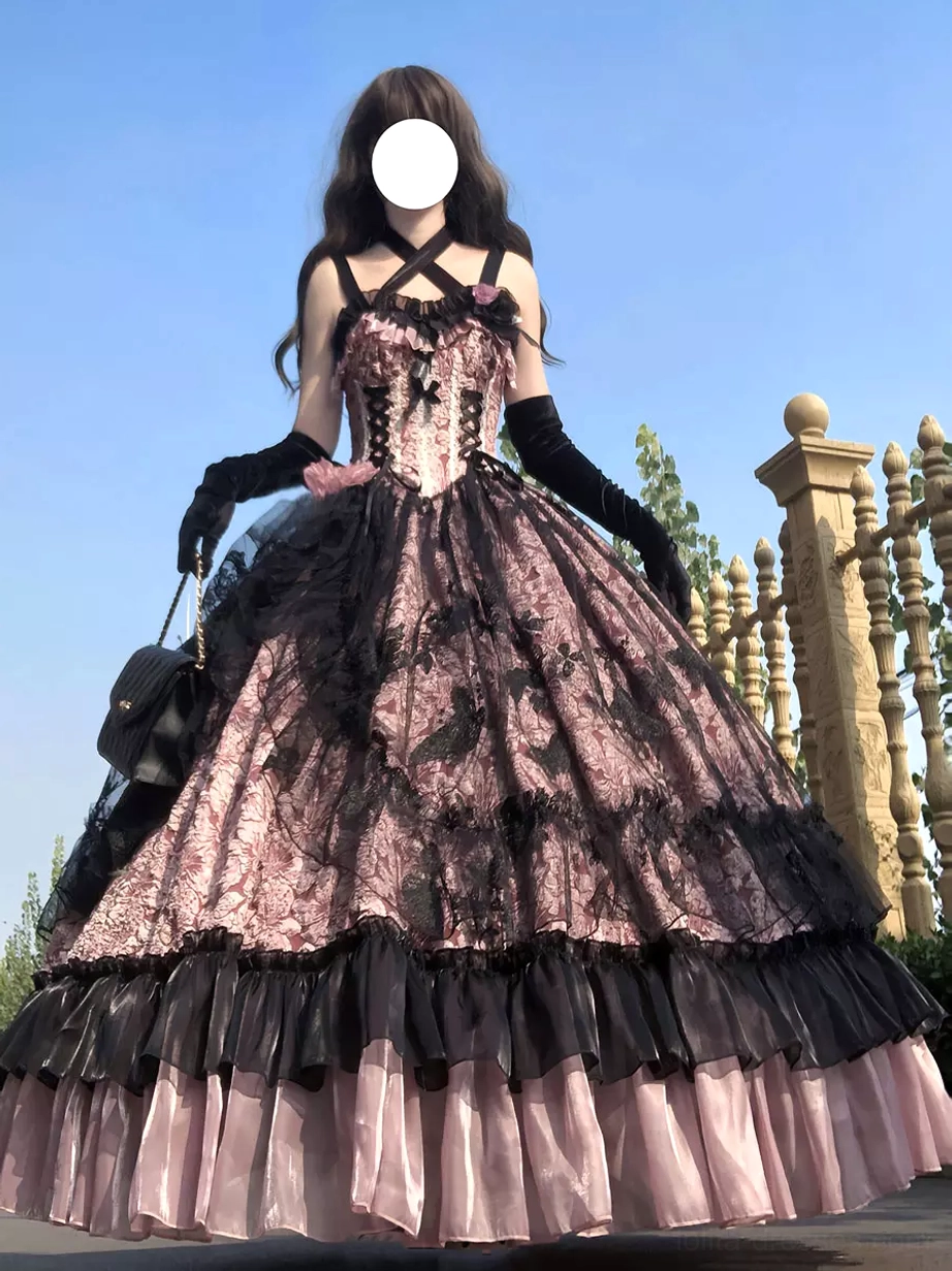 Full-length model wearing pink and black gothic Lolita ball gown with layered tulle skirt and accessories in European outdoor fence setting