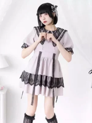 Light pink and black gothic lolita sailor dress with lace splicing front view on model showing short puff sleeves and layered ruffle hem with tassel details