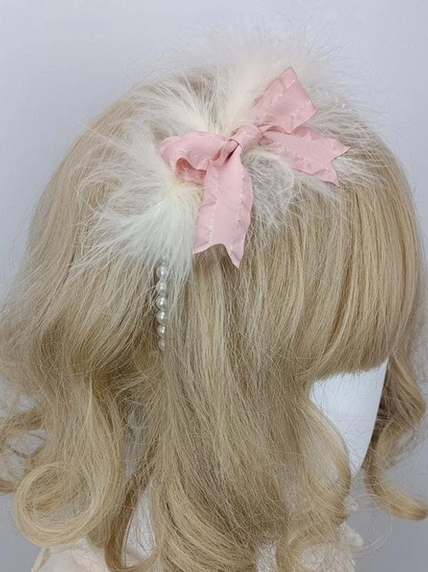 Pink satin bow lolita hair accessory with fluffy white feather and pearl trim, back three-quarter view, sweet romantic headdress