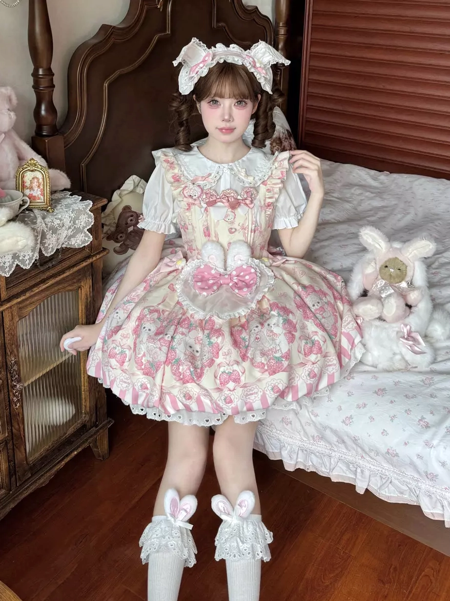 Pink bunny lolita dress sitting pose bedroom setting model wearing matching bunny hair bow lace ruffled socks sleeveless silhouette cute animal print aesthetic