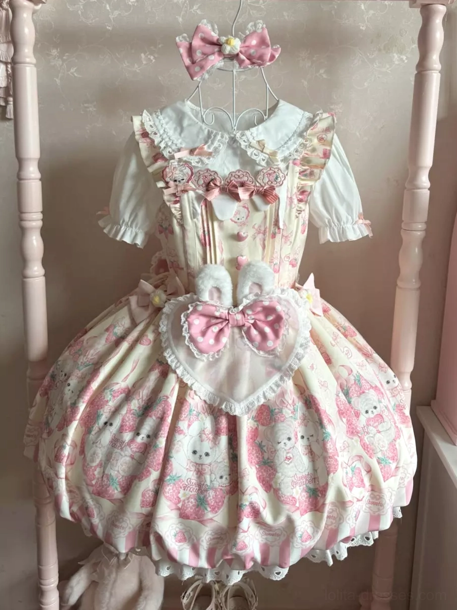 Pink bunny print sweet lolita dress front display hung on pink four-poster bed frame showing rabbit pattern heart-shaped pocket with pink bow sleeveless puff skirt design details