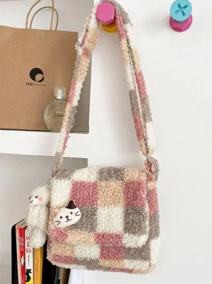 Pink checkered fleece Lolita shoulder bag hanging display showing adjustable strap and cute cat badge with teddy bag charm