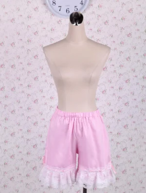 Front view of pink cotton lolita bloomers with white lace ruffled hem and elastic waistband, displaying the classic sweet lolita aesthetic with delicate shirring details