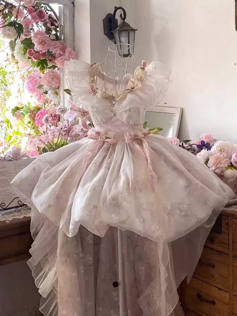 Pink fairy lolita dress with tiered ruffles and floral print, displayed on dress form in vintage interior setting with puff skirt and waist flower embellishments
