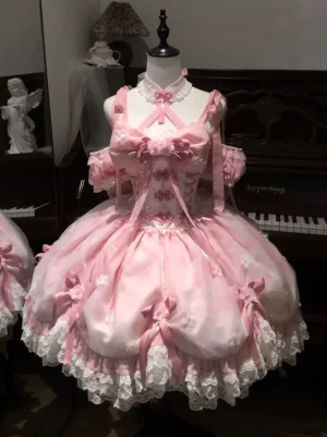 Pink sweet fairy lolita JSK dress full front view with dimensional front bow and off-shoulder straps, displayed on dress form mannequin indoors