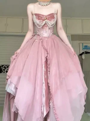 Pink fairy lolita velvet corset maxi dress with pearl chain detailing and layered asymmetrical tulle skirt - front three-quarter view showing full silhouette and design details