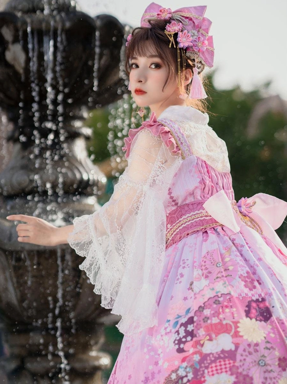 Pink floral slip lolita dress showing side view with back bow decoration sleeveless ruffled top near fountain