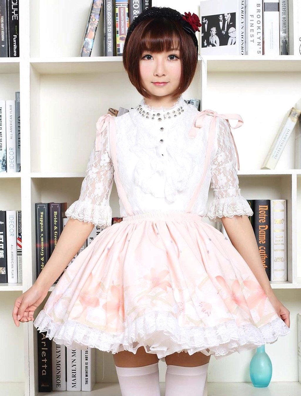 Pink floral sweet lolita JSK dress with white lace sleeves front full-body view on model with bookshelf background