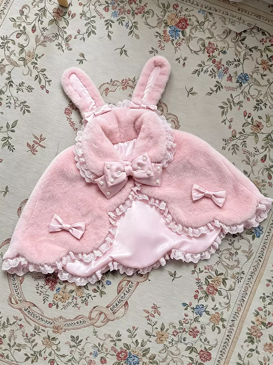 Pink fuzzy bunny ear plush lolita shawl with pink lace trim and small pink bows, flat lay on vintage floral background