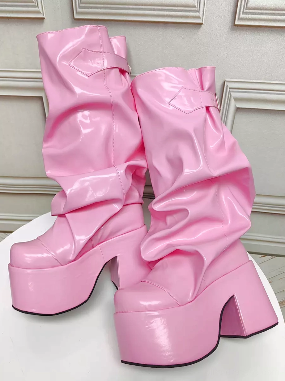 Pair of pink slouchy Gothic Lolita platform boots side three-quarter view showing black outsole edge ankle buckle strap rounded toe and chunky heel