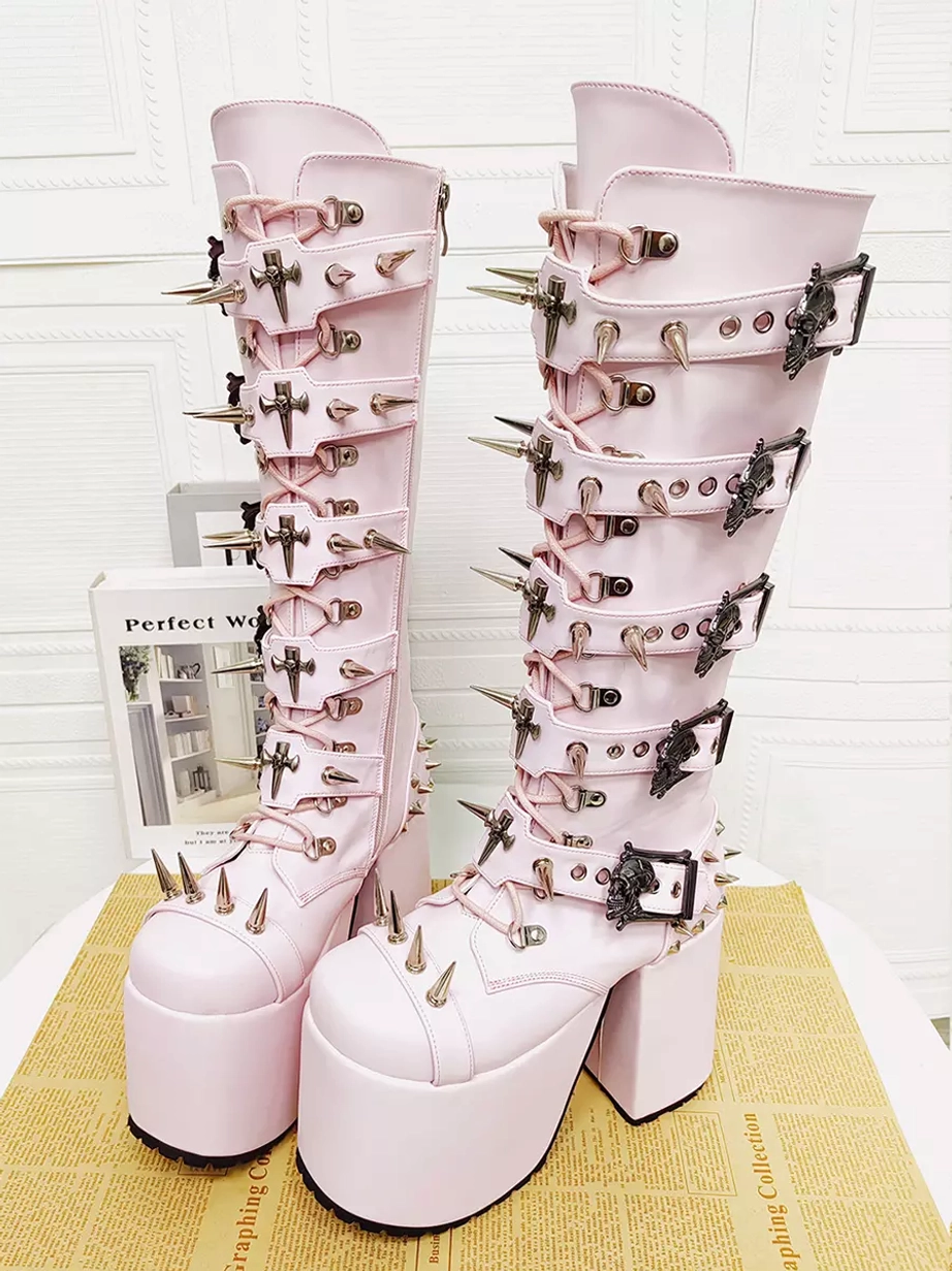 Pink gothic punk platform boots front view on desktop with book decor spike strap buckles thick platform sole round toe
