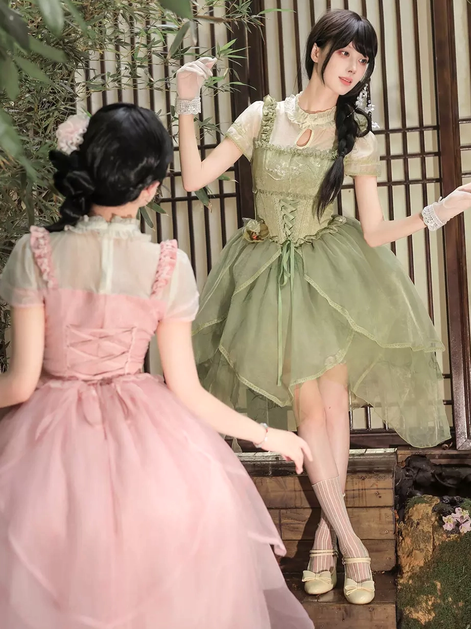 Side and back view of pink and green sweet lolita dresses showing asymmetrical tulle hem layering and matching short sleeve inner construction in bamboo garden scene