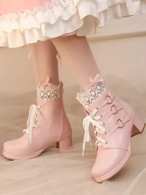 Pink lolita boots side rear view showing heart-shaped metal buckles, block heel construction, lace collar details, paired with white ruffled skirt and dotted stockings