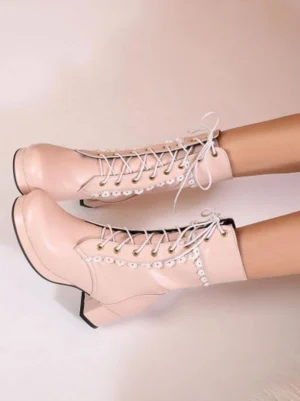Pink PU leather lace-up Lolita boots with round toe and block heel, adorned with white floral lace collar trim on light pink background