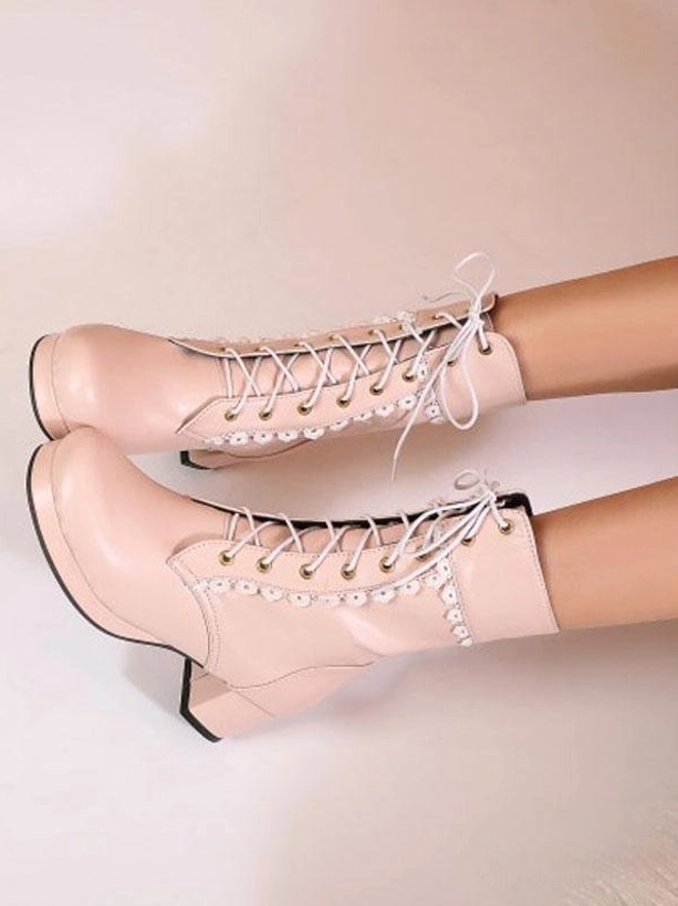 Pink PU leather lace-up Lolita boots with round toe and block heel, adorned with white floral lace collar trim on light pink background