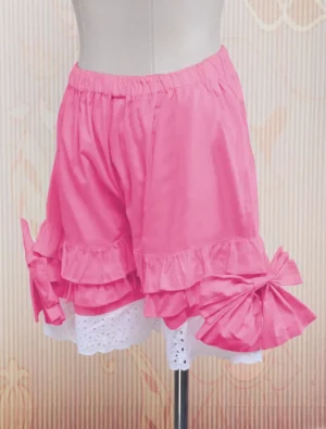 Pink lolita bloomers featuring layered ruffled trims and visible left-side bow, front right three-quarter view on mannequin with vintage aesthetic background