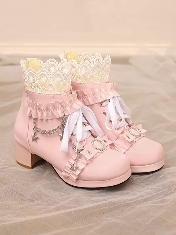 Pink Lolita ankle boots flat lay oblique view with crown lace detailing, star chain charms, ruffle trims, and sheer fabric backdrop