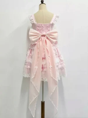Back view of pink lolita dress with attached detachable bow train tail showing layered ruffled skirt and shirred neckline