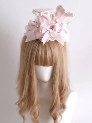 Front view of pink lolita hair fascinator with bunny ears multiple layered satin bows and lace edging on blonde wavy wig mannequin display