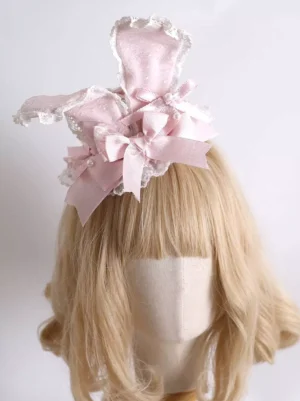 Pink lolita bunny ear headdress with satin bows and lace trim worn on mannequin with blonde bangs wig left front view sweet lolita hair accessory