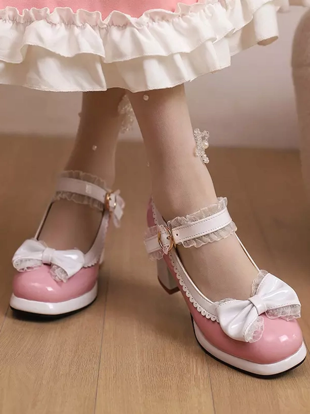 Pink Lolita chunky heel pumps with dual white bow decorations worn with pink ruffle skirt side three-quarter view