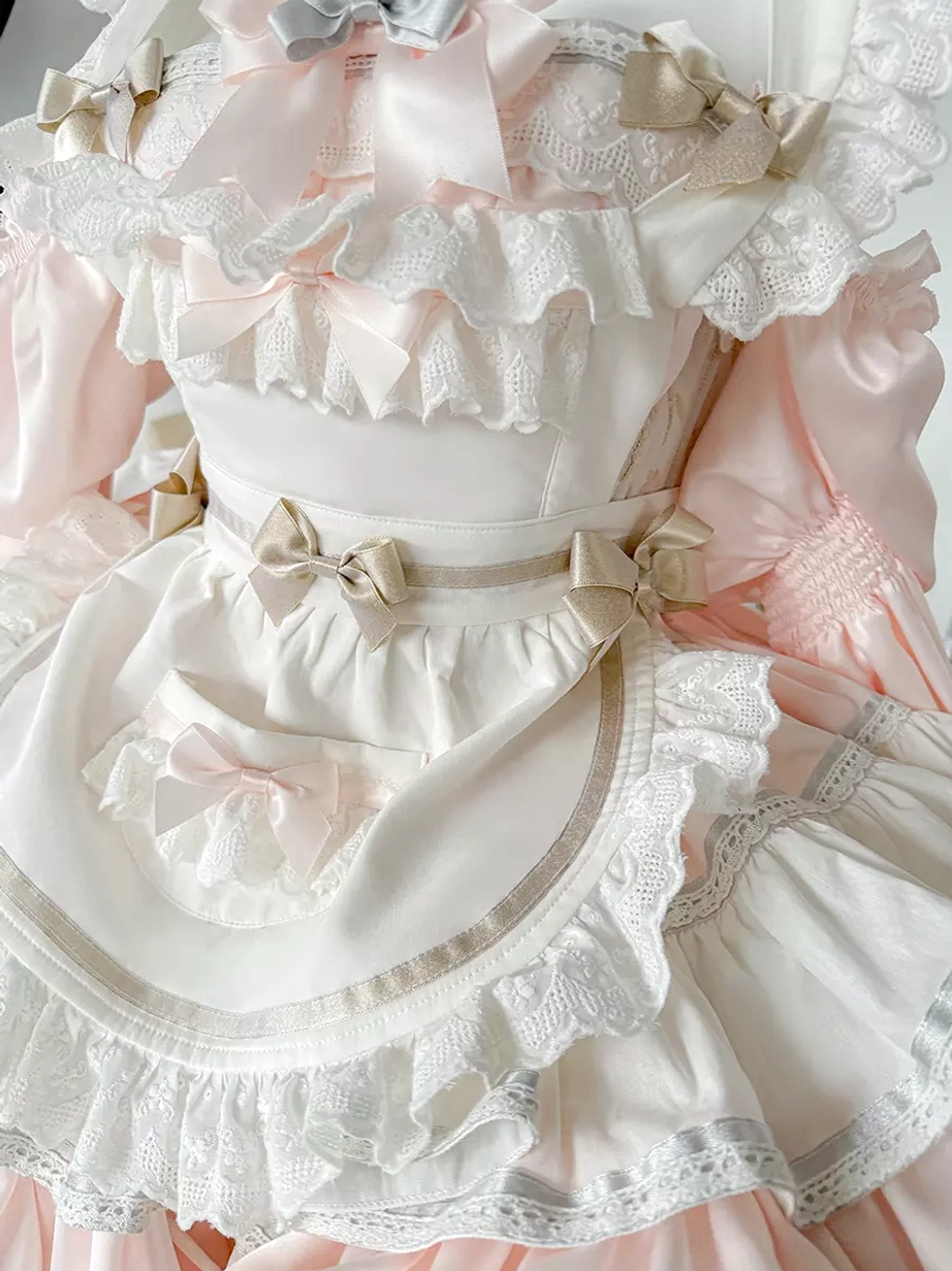 Pink lolita dress back view showing lace-up corset closure, layered ruffled construction, and ribbon bow accent in authentic sweet maid style