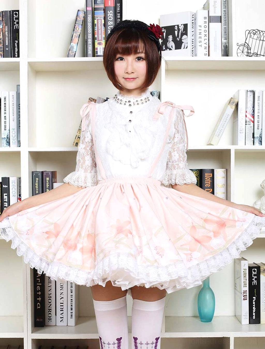 Pink floral lolita dress front view model holding skirt with white thigh-high socks and lace-trimmed hem