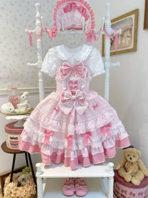 Pink lolita dress with ruffled inner shirt white trim and pink bow decorations full front view on mannequin display