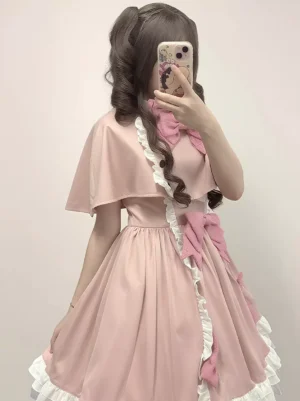 Pink lolita dress ensemble side profile view showing side bow detail, fitted waist construction, ruffled skirt trim, and full skirt silhouette on model with long curly hair